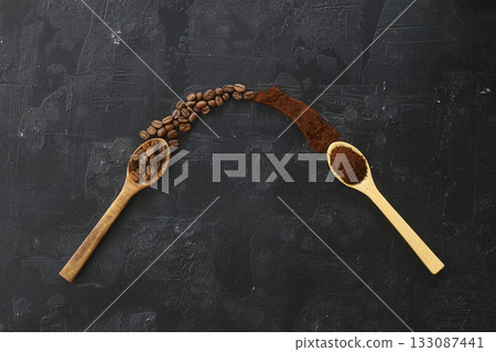 two spoons with coffee on a black background. One spoon with coffee beans. Second spoon with ground coffee. two spoons with coffee on a black background. One spoon with coffee beans. Second spoon with ground coffee. 133087441