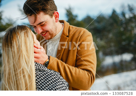 happy couple kissing and hugging in the park on a snowy winter day 133087528