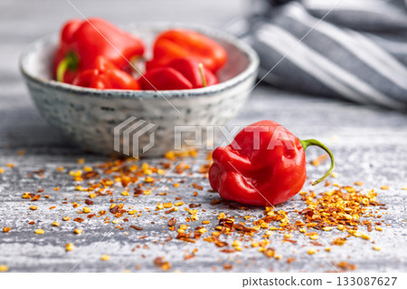 Red chili pepper habanero and chili flakes on kitchen table. Red chili pepper habanero and chili flakes on kitchen table. 133087627