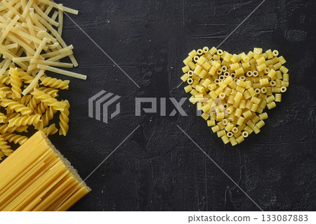 Pasta in the shape of a heart on a black background. 133087883