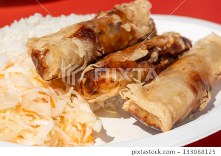 Fried spring rolls. Crispy springrolls, roasted egg rolls with boiled rice and cabbage salad 133088125
