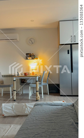 Cozy dining corner with warm evening light in modern home. Domestic interior, comfort, and calm everyday lifestyle with cozy details. Cozy dining corner with warm evening light in modern home. Domestic interior, comfort, and calm everyday lifestyle with cozy details. 133088364