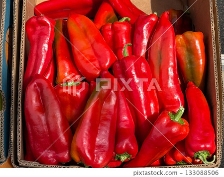 Red bell peppers displayed in wooden crate. Fresh produce, organic agriculture, and healthy vegetarian nutrition concept. 133088506