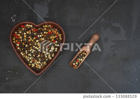 Mixture of peppercorns in heart shape isolated on black background Mixture of peppercorns in heart shape isolated on black background 133088529