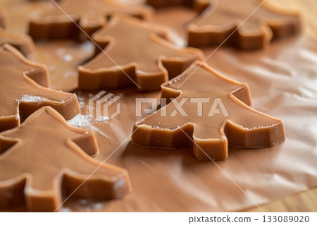 Christmas tree-shaped cookie cutters rest on a surface, ready for baking and decorating delicious holiday treats during the festive season 133089020