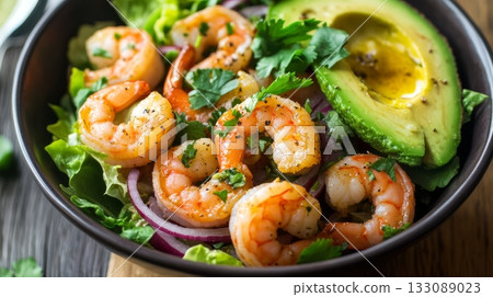 A delicious shrimp avocado salad features grilled shrimp, fresh greens, and sliced avocado, garnished with herbs, perfect for a healthy meal 133089023
