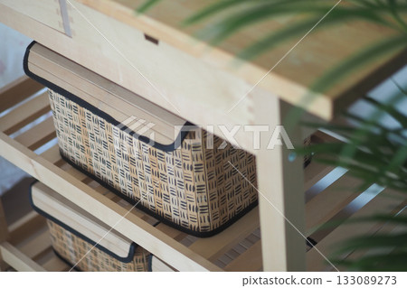 Storage baskets on wooden shelves in a cozy room setup 133089273
