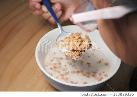 Enjoying a healthy breakfast with oatmeal and milk Enjoying a healthy breakfast with oatmeal and milk 133089330