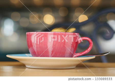 Colorful cup of coffee on a saucer at a cafe Colorful cup of coffee on a saucer at a cafe 133089333