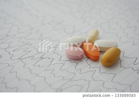 Medications arranged on a wavy medical report backdrop Medications arranged on a wavy medical report backdrop 133089383