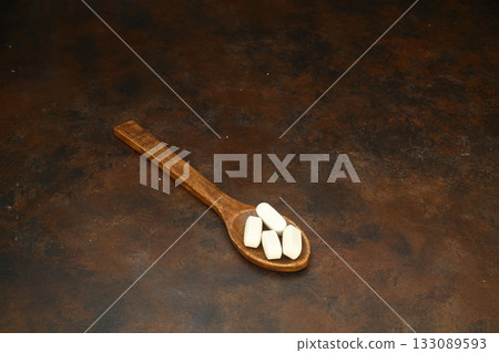 Healthcare concept of ladle with spoon of various medicine tablet, caplets, pills, capsule on rusty background 133089593