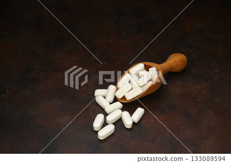 Healthcare concept of ladle with scoop of various medicine tablet, caplets, pills, capsule on rusty background 133089594