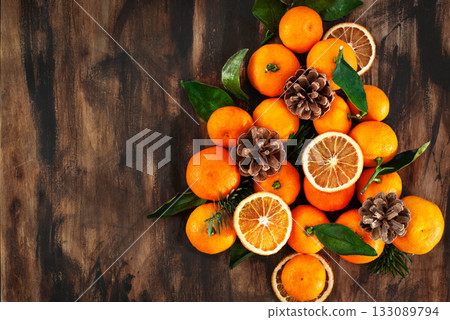 Christmas tree of fresh ripe tangerines with leaves, cones and fir tree branches Christmas tree of fresh ripe tangerines with leaves, cones and fir tree branches 133089794