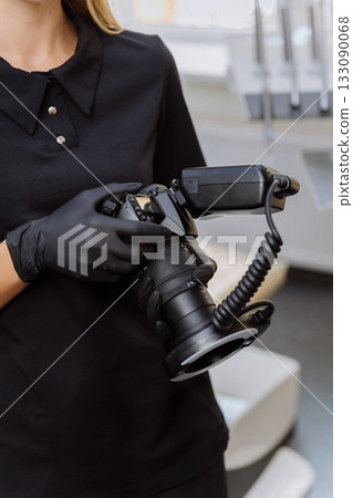 Gloved dental clinician holding DSLR with macro ring flash for intraoral photography 133090068