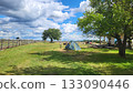 Camping in a tranquil setting with clouds and open fields under a blue sky during the day 133090446