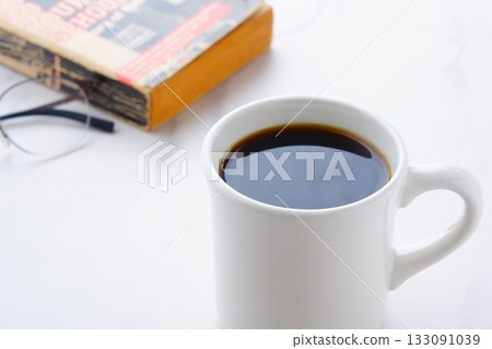 An image of someone relaxing and reading while sipping aromatic freshly brewed coffee 133091039