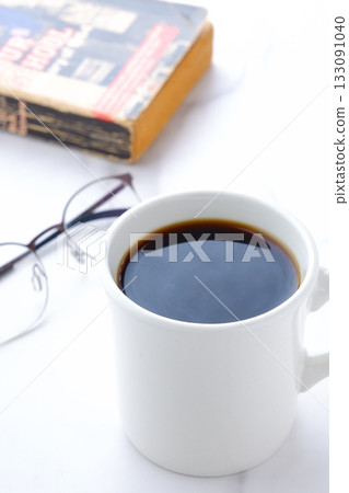 照片中,一個人一邊放鬆、一邊看書,一邊喝著香濃的現煮咖啡。 照片中,一個人一邊放鬆、一邊看書,一邊喝著香濃的現煮咖啡。 133091040