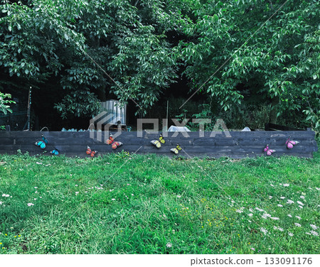 Butterflies on a fence decor. Garden and simple decorations Butterflies on a fence decor. Garden and simple decorations 133091176