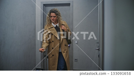 Female Guest With Backpack And Rolling Suitcase Moves Through Minimalist Hotel Corridor 133091658