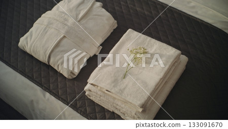 Hotel Housekeeper in White Gloves Carefully Folds Fresh White Towels and Bathrobe on Neatly Made Bed 133091670