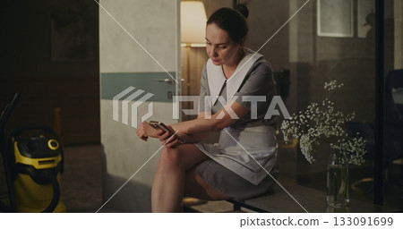 Hotel Housekeeper Takes Short Break in Room Chair Hotel Housekeeper Takes Short Break in Room Chair 133091699