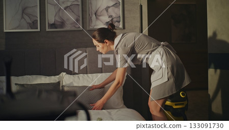 Hotel Housekeeper Takes Short Break in Room Chair 133091730