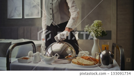 Room Service Attendant Serving Gourmet Breakfast in Hotel 133091734