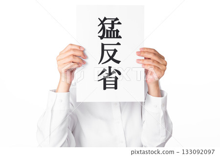 A person wearing a white shirt holding a piece of paper with the words "deep remorse" written on it 133092097