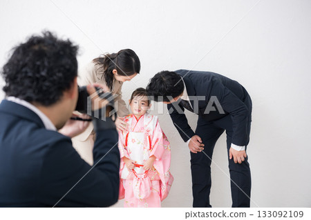 一家人和攝影師在室內拍攝全家福,慶祝七五三節或週年紀念日 一家人和攝影師在室內拍攝全家福,慶祝七五三節或週年紀念日 133092109