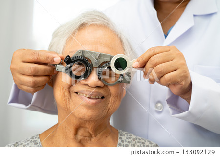 Asian senior woman wearing ophthalmic vision eye test and using optical trial frame. Asian senior woman wearing ophthalmic vision eye test and using optical trial frame. 133092129