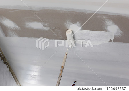 Handyman painting gypsum ceiling panel in kitchen. Handyman painting gypsum ceiling panel in kitchen. 133092287