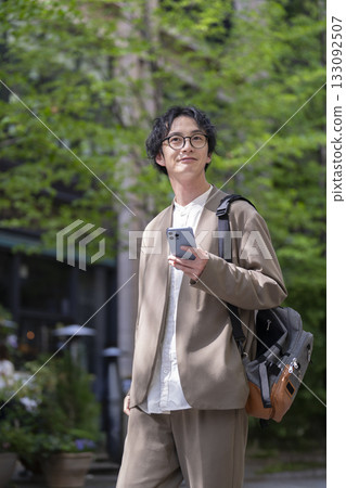 A man in his late 30s holding a smartphone A man in his late 30s holding a smartphone 133092507