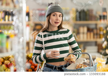 Visiting store on New Years Eve, girl is looking at something on shelf of showcase. Visiting store on New Years Eve, girl is looking at something on shelf of showcase. 133093188