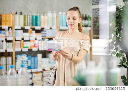 Woman in a summer dress chooses pills for toxicosis 133093625