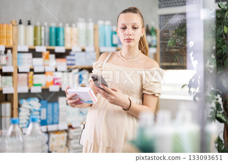 Pregnant woman in pharmacy scans QR code tablet medication product Pregnant woman in pharmacy scans QR code tablet medication product 133093651