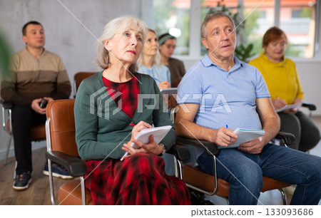 Older male and female students listening to lecture in university Older male and female students listening to lecture in university 133093686