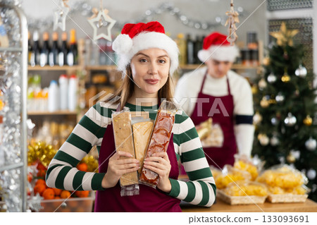 Young woman seller offering nougat in grocery store 133093691