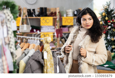 Latina chooses a fur coat in the store 133093879
