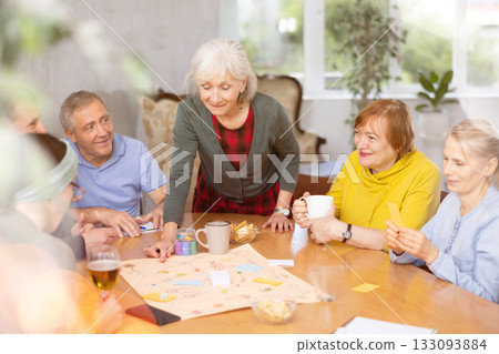 Group of mature friends at home, playing board games 133093884