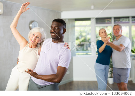 Elderly woman dancing merengue with african american partner 133094002