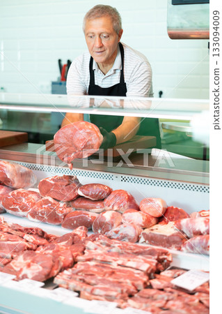 Male farmer of meat products in butcher shop offers to buy fresh beef tenderloin. Male farmer of meat products in butcher shop offers to buy fresh beef tenderloin. 133094009