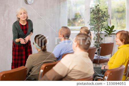 Older female teacher explaining subject to mature students 133094051