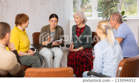 Young female tutor leading educational class for group of elderly Young female tutor leading educational class for group of elderly 133094052