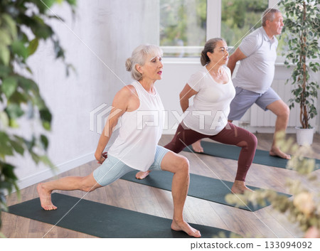 Elderly women adn man practicing various yoga positions during training Elderly women adn man practicing various yoga positions during training 133094092