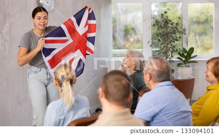 Young female teacher showing british flag to mature students 133094101