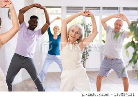 Active mature men and women practicing Jazz-funk dance in training hall Active mature men and women practicing Jazz-funk dance in training hall 133094121
