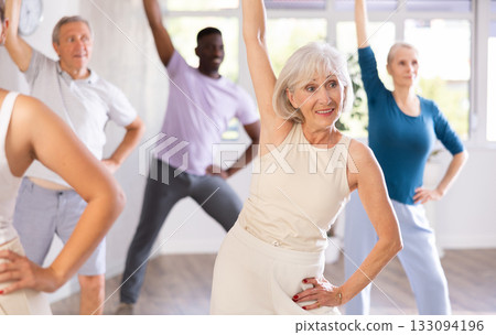 Mature men and women practicing Rock 'n' Roll dance in training hall Mature men and women practicing Rock 'n' Roll dance in training hall 133094196