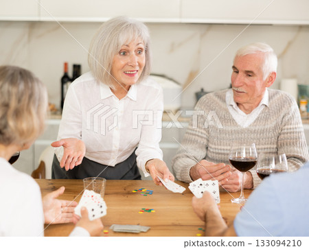 Two mature married couples playing card game poker 133094210