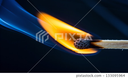 Ignited matchstick illuminating the darkness with bright flames creating intriguing smoke trails 133095964
