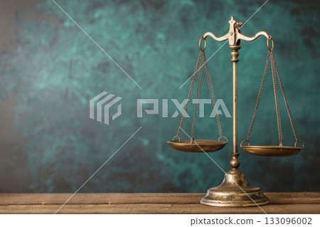 A classic metal balance scale symbolizing justice and fairness, set against a textured teal background for legal themes. 133096002